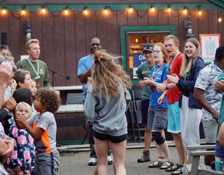 Girl busts out dance moves in the middle of a dance circle at summer camp