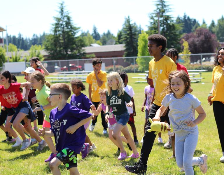 Summer Day Campers running in the field during a camptivity at the YMCA
