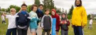 Group Smiling With Volunteers At YMCA Summer Day Camp