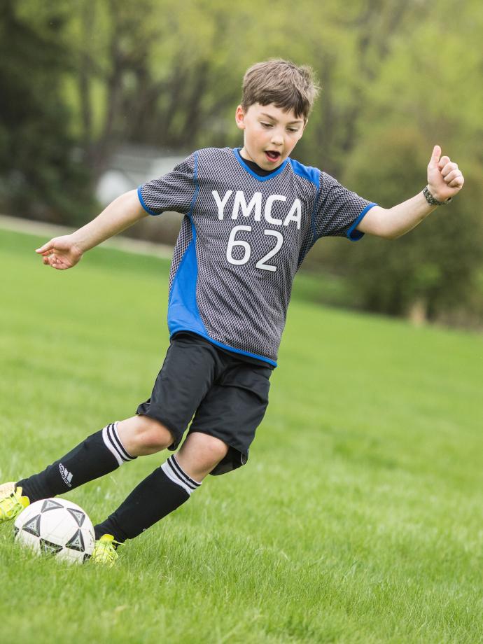 Kicking Ball Down Field at YMCA Youth Soccer League