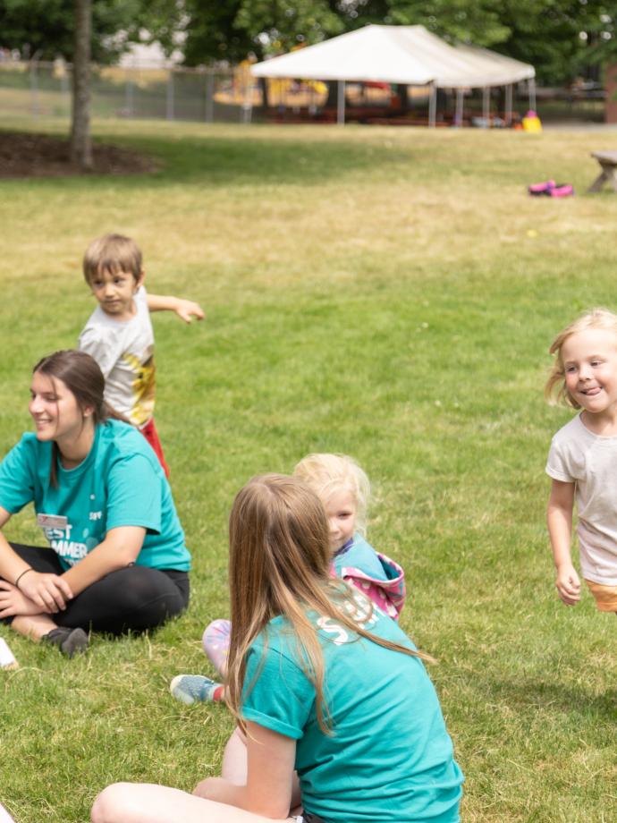 Campers playing duck duck goose at summer camp