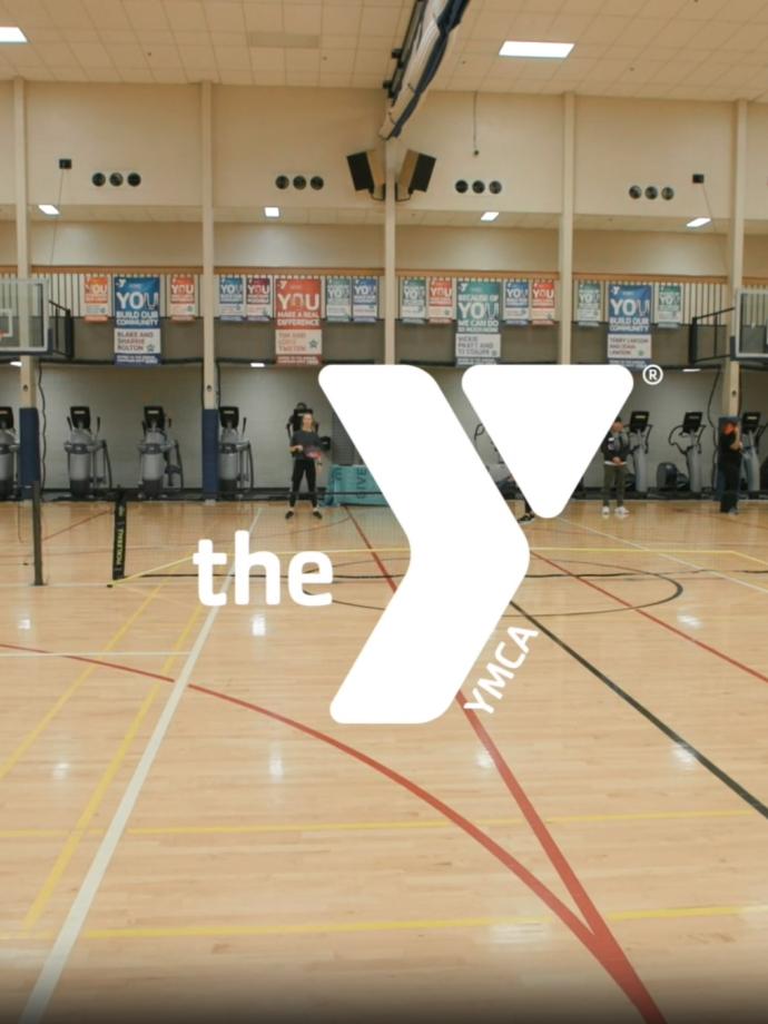 Action shot of a pickleball game with YMCA logo superimposed in the center