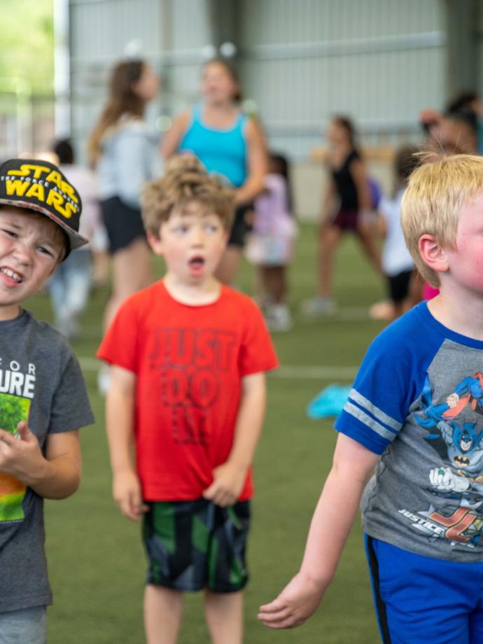 Kids smiling in a play field at summer day camp