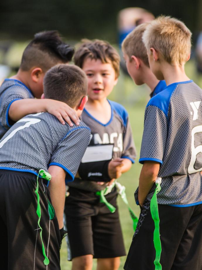 Flag football players huddle to plan an offensive play