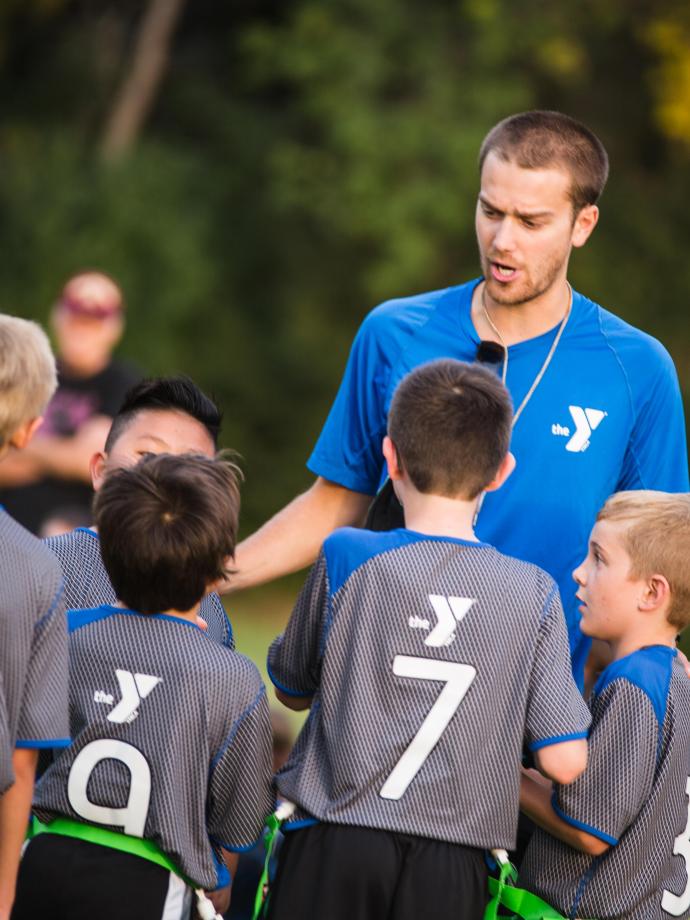 Flag football coach leads team huddle