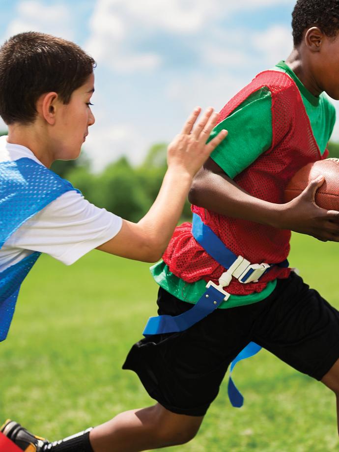 Action shot of a flag football player running the ball