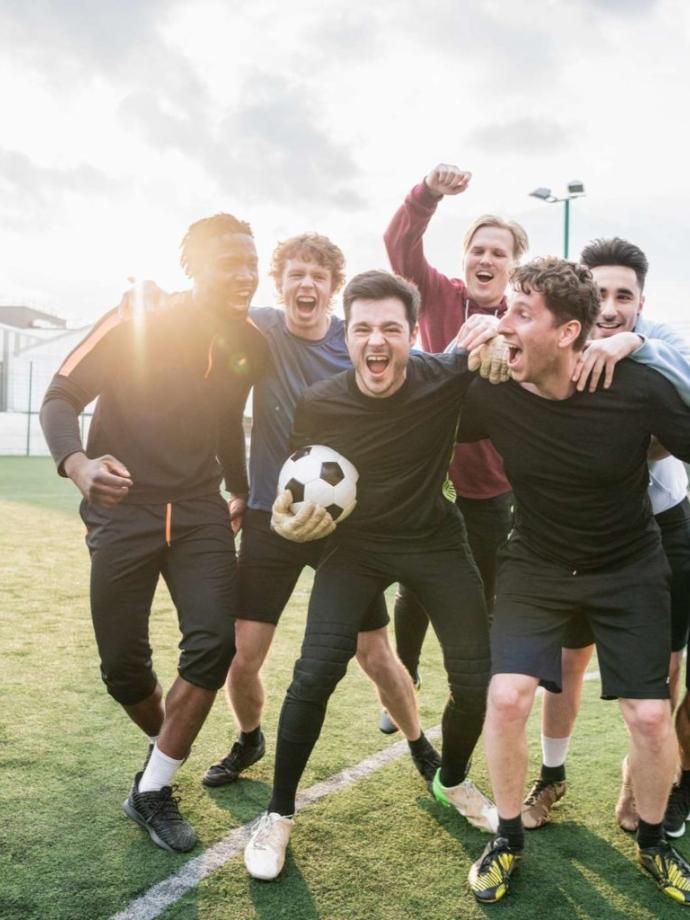 Adult soccer team cheers together after a victory at the YMCA