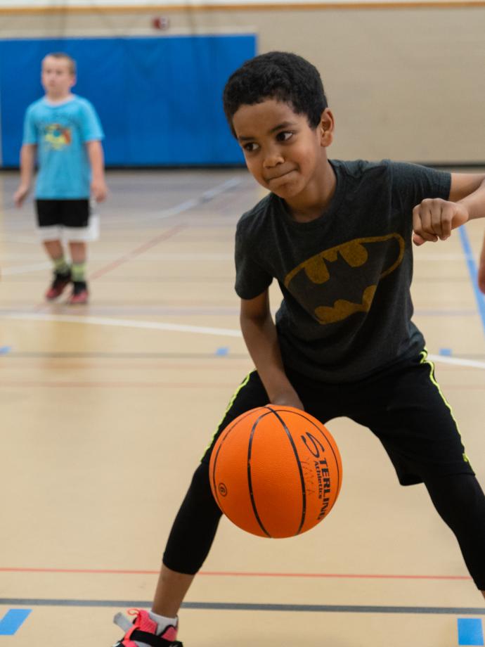 Basketball participant practices dribble drill during practice at the YMCA