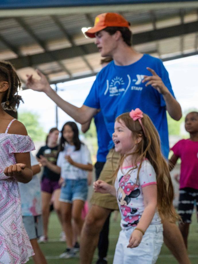 Summer camp participants dance during music time at the YMCA