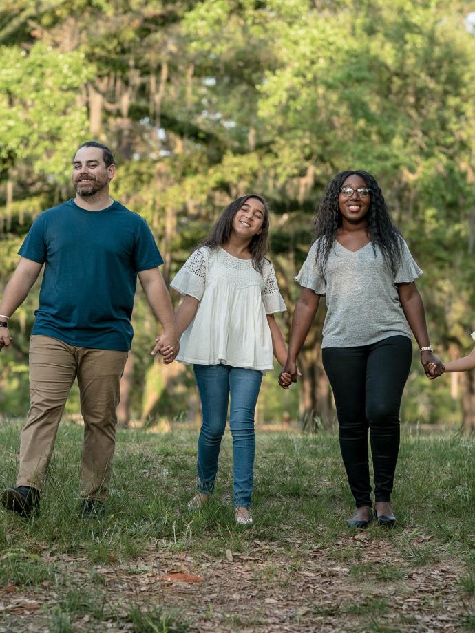 Family Holding Hands In The Park