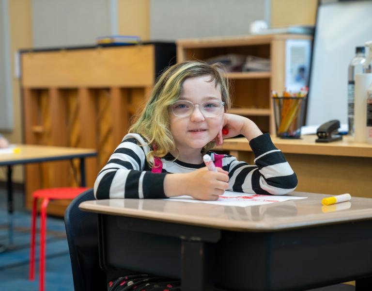 School Age Student Smiling At YMCA Child Care Desk