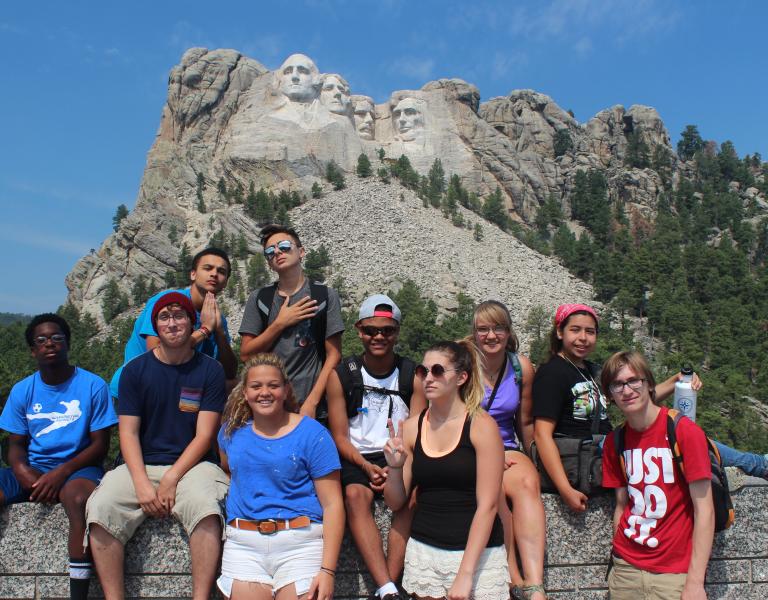 Teen leadership group posing in front of Mt. Rushmore