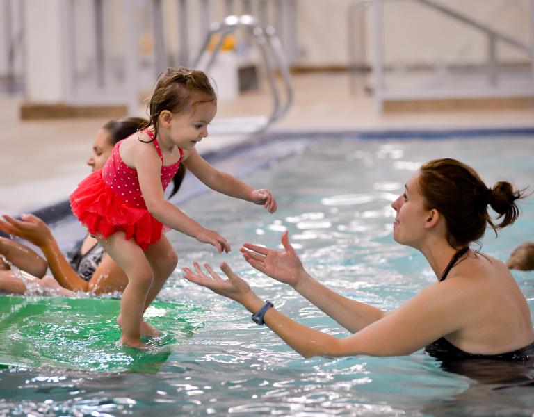 child about to jump into water during open swim