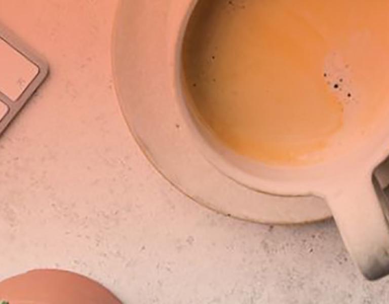 Overhead shot of a coffee mug next to a keyboard