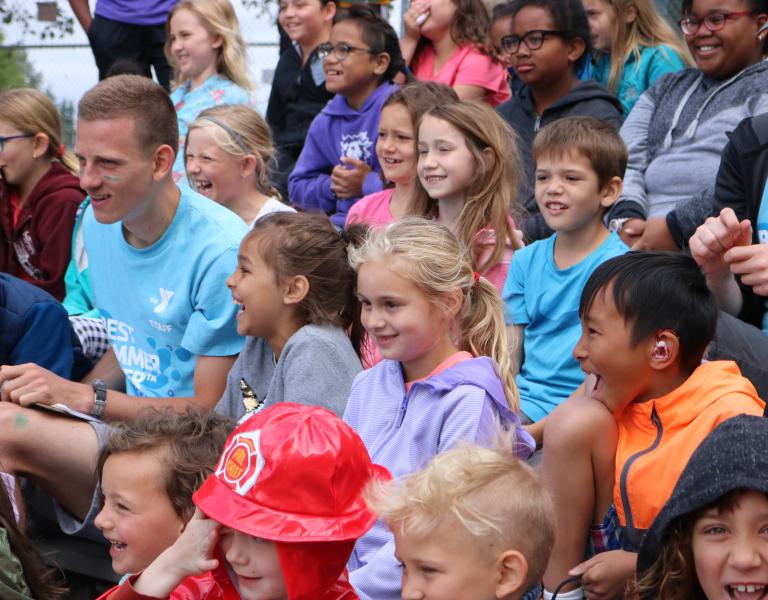 Summer camp participants in audience watching a skit