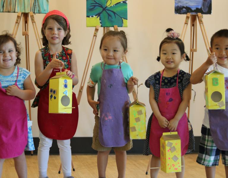 Art preschoolers lining up to show off their carton bird houses at the YMCA