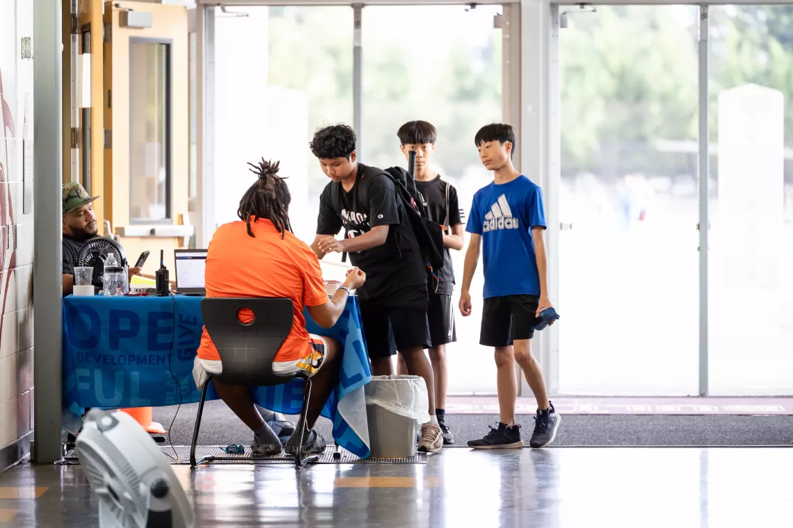 Late Nite teens check in at the welcome desk at the YMCA
