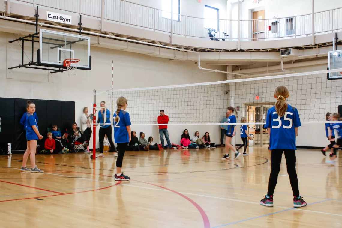 Volleyball players wait for the next serve during a game at the YMCA