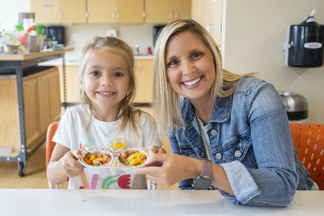 Mother and daughter show off their dessert creations made during culinary arts class at the YMCA