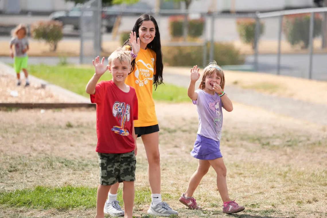 YMCA Summer Camp Counselor Waving with Campers