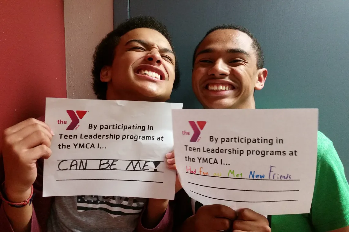 Friends Smiling with Signs at YMCA Kids Nite Out Leadership Program