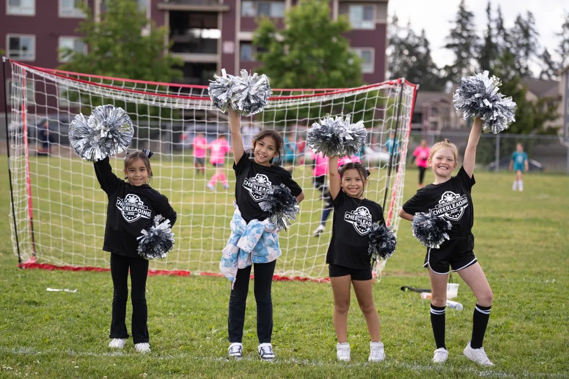 Group of YMCA Cheerleaders Cheering in Front of Goal