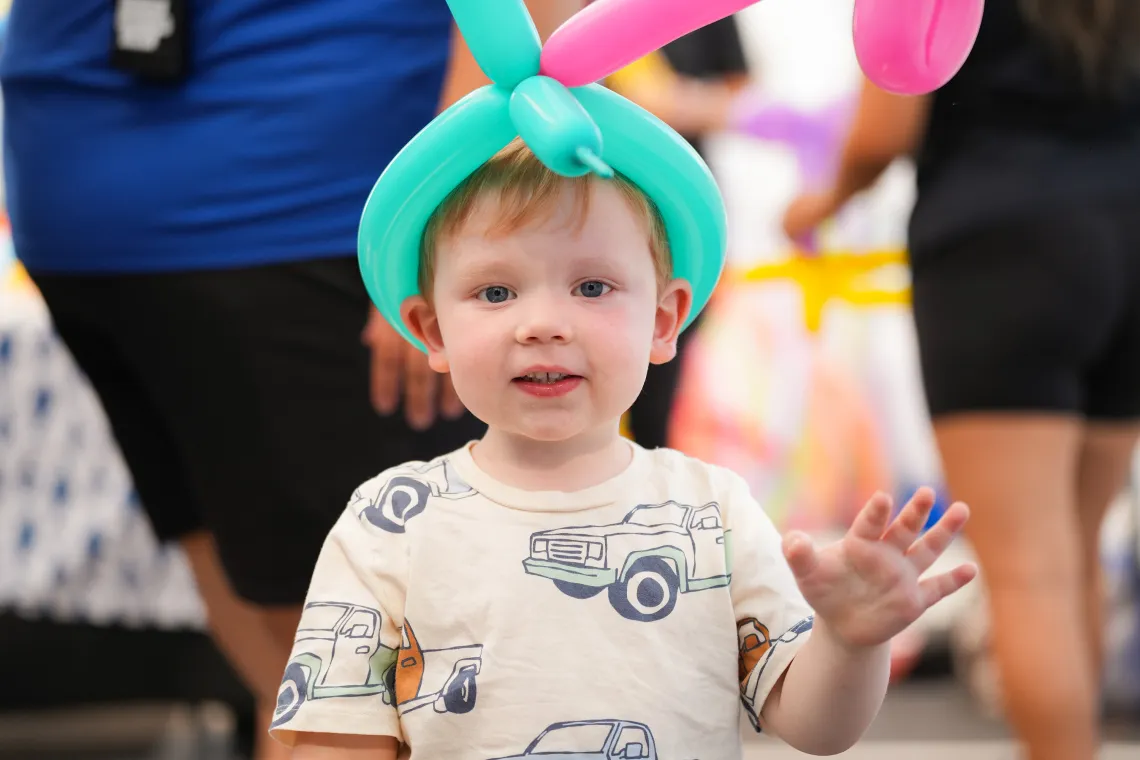 Toddler with Balloon Hat at YMCA Event