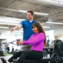 YMCA Member Rowing with Personal Trainer