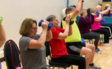 Active older adults lift weights in a senior strength class to improve balance, flexibility, strength, and stability.