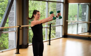 A young woman works out with weights in a fitness studio at YMCA of Pierce and Kitsap Counties.