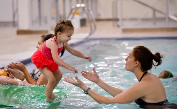 child about to jump into water during open swim