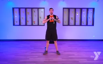 YMCA360 Instructor Bryce holds free weights and leads a newly released class.