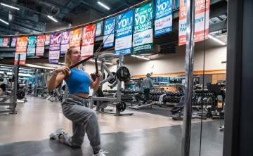Woman doing kneeling high cable rows