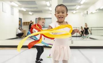Toddler ballet students play with flow ribbons at the YMCA