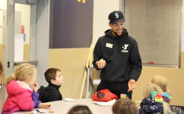 Child care staff leading a fun game during snack time at the YMCA