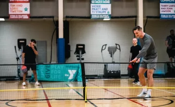 Pickleball player sets up to serve the ball at the YMCA