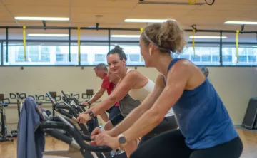Action shot of an indoor cycling class held at the Tacoma Center YMCA