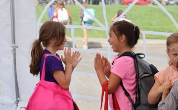 Summer camp participants engage in a fun game while waiting in line at the YMCA
