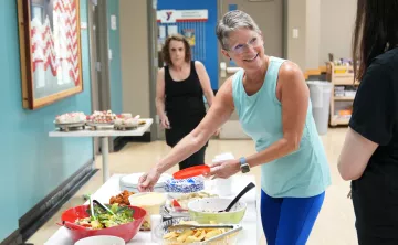 Stacey smiling as she sets up a potluck table