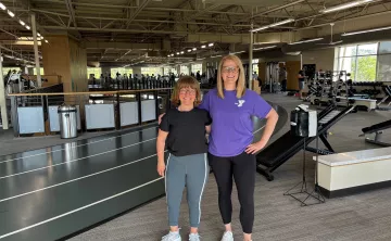 Jaclyn and Katie smile together in the gym