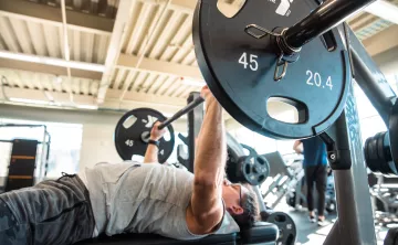 Action shot of a member bench pressing at the YMCA