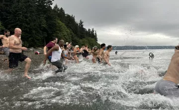 Action shot of the Plunge participants running into the water at Owen's Beach