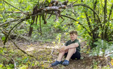 Trevor in front of a forest fort