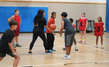 Coach Ali plays basketball with her team