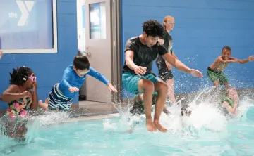 Kids jump in the pool at Y Camp at the YMCA