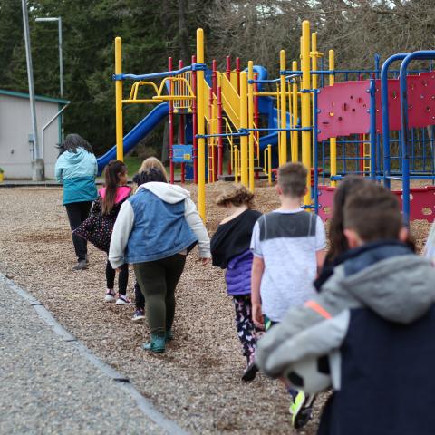 Child care students line up before school to get into the playground at the YMCA before and after school care facility.