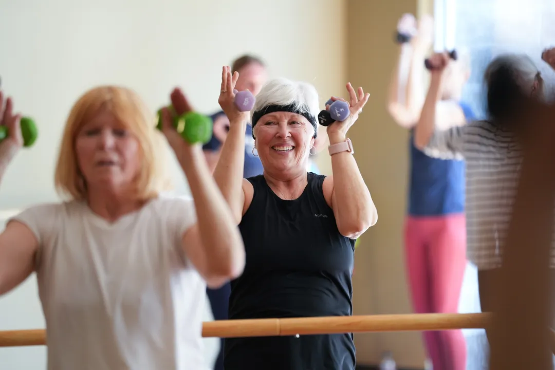 Active Older Adult Lifting Weight Overhead in YMCA Group Exercise Class